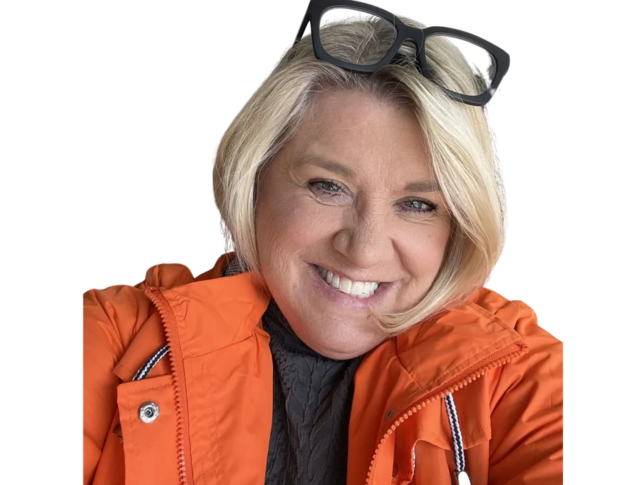 Author Sharmyn McGraw, smiling, in an orange jacket